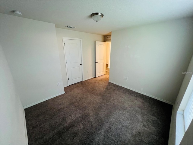 unfurnished bedroom featuring dark carpet