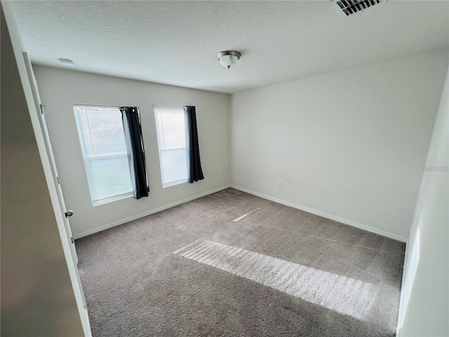 carpeted spare room with a textured ceiling