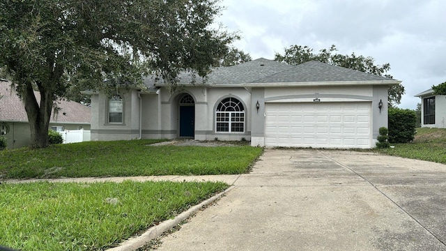 single story home with a garage and a front lawn