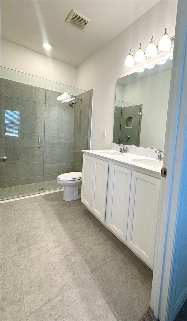 bathroom with tile patterned floors, vanity, toilet, and walk in shower