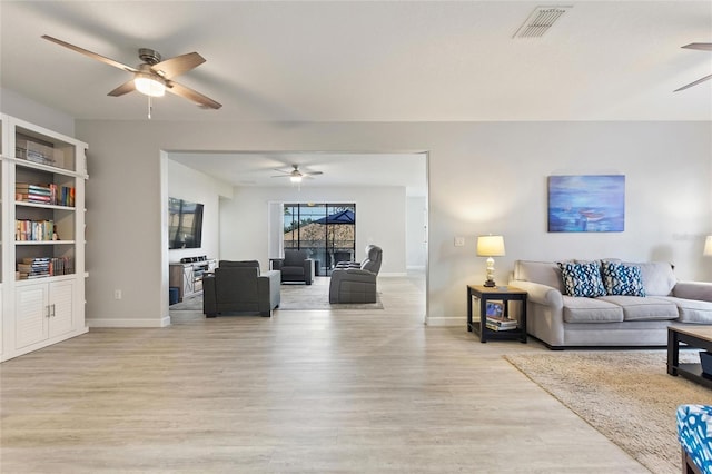 living room featuring built in features and light wood-type flooring