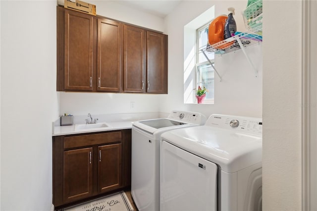 laundry area featuring cabinets, independent washer and dryer, and sink