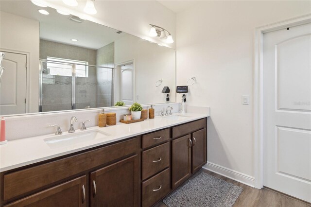 bathroom with hardwood / wood-style floors, vanity, and an enclosed shower