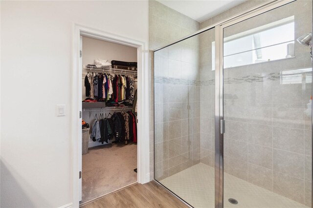 bathroom with hardwood / wood-style flooring and a shower with door