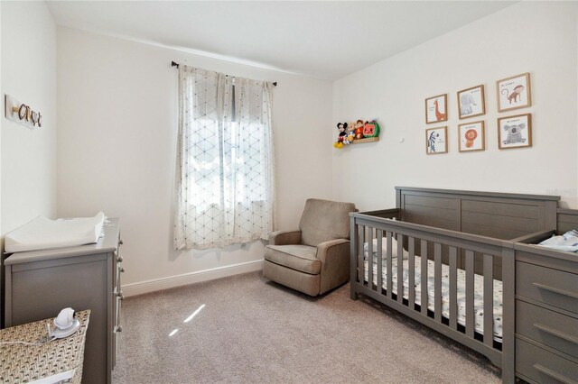 carpeted bedroom with a nursery area