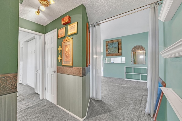 corridor featuring carpet and a textured ceiling