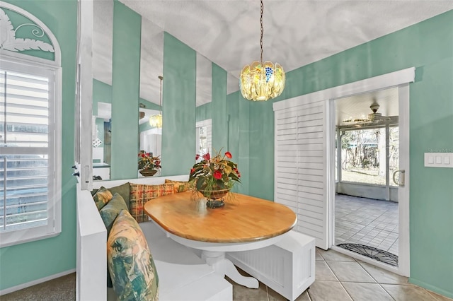 tiled dining area with a chandelier, breakfast area, and a wealth of natural light