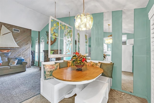 dining space with carpet flooring, breakfast area, lofted ceiling, and an inviting chandelier