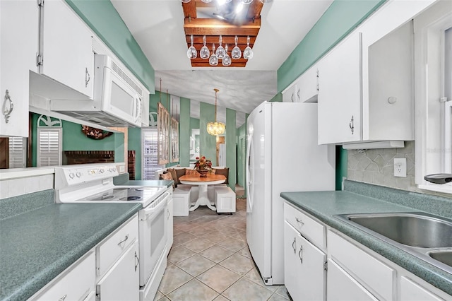 kitchen with white appliances, white cabinets, hanging light fixtures, decorative backsplash, and light tile patterned floors