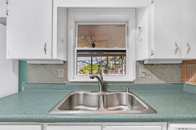 kitchen with backsplash, sink, and white cabinets