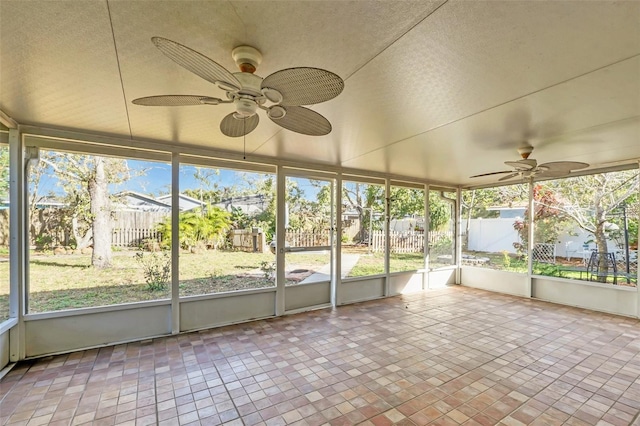 unfurnished sunroom featuring ceiling fan