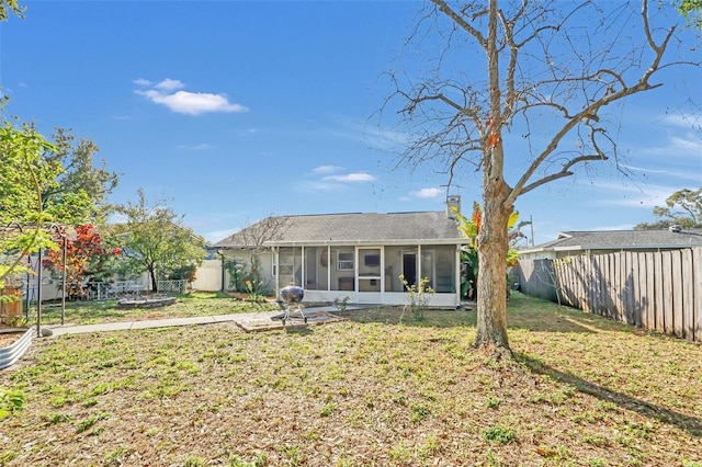 back of house with a lawn and a sunroom