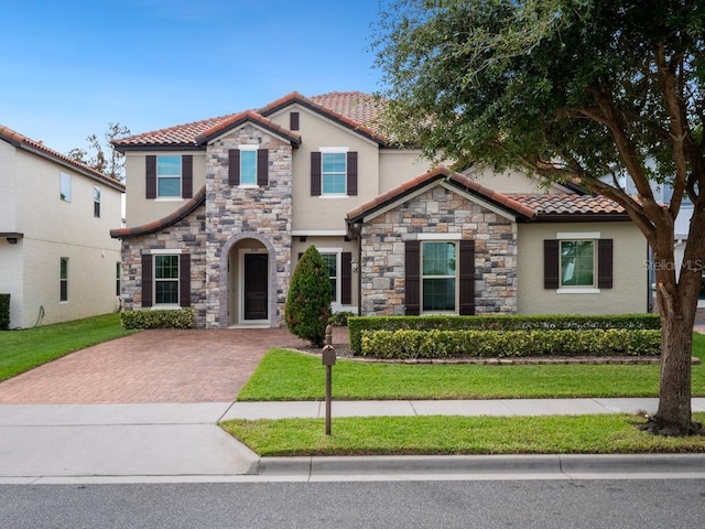 mediterranean / spanish-style house with a front yard