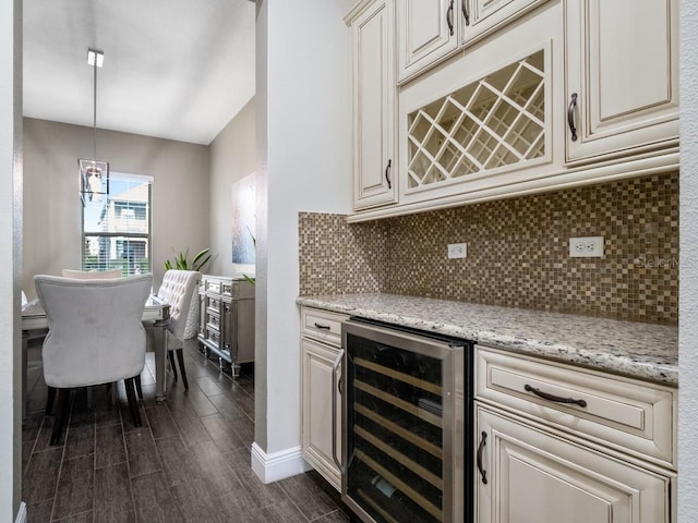 kitchen featuring tasteful backsplash, light stone counters, beverage cooler, dark wood-type flooring, and pendant lighting