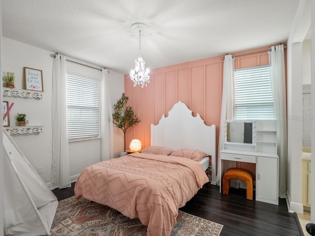 bedroom with a chandelier and dark hardwood / wood-style floors