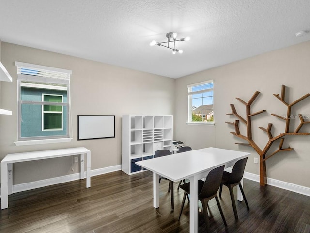 dining area featuring a textured ceiling, dark hardwood / wood-style floors, and an inviting chandelier