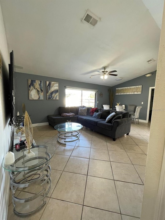 living room with ceiling fan, light tile patterned floors, and vaulted ceiling