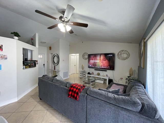 living room featuring ceiling fan, lofted ceiling, and light tile patterned floors