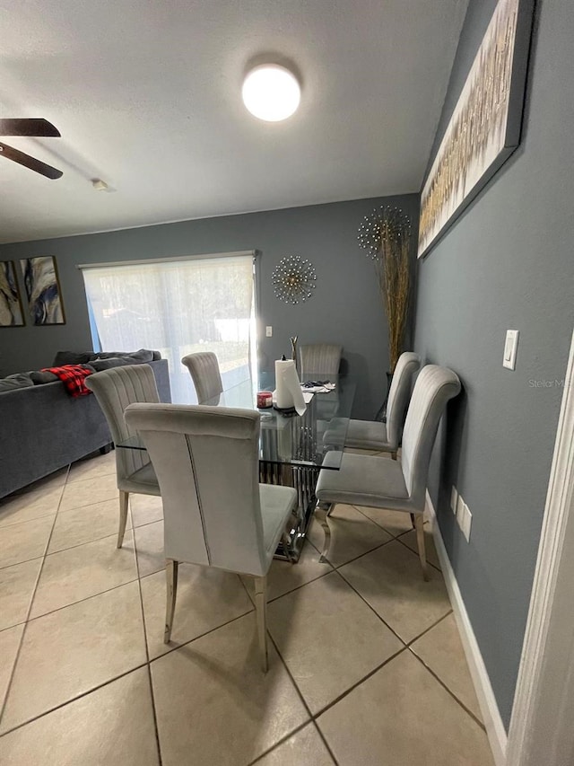 dining space with ceiling fan and light tile patterned flooring