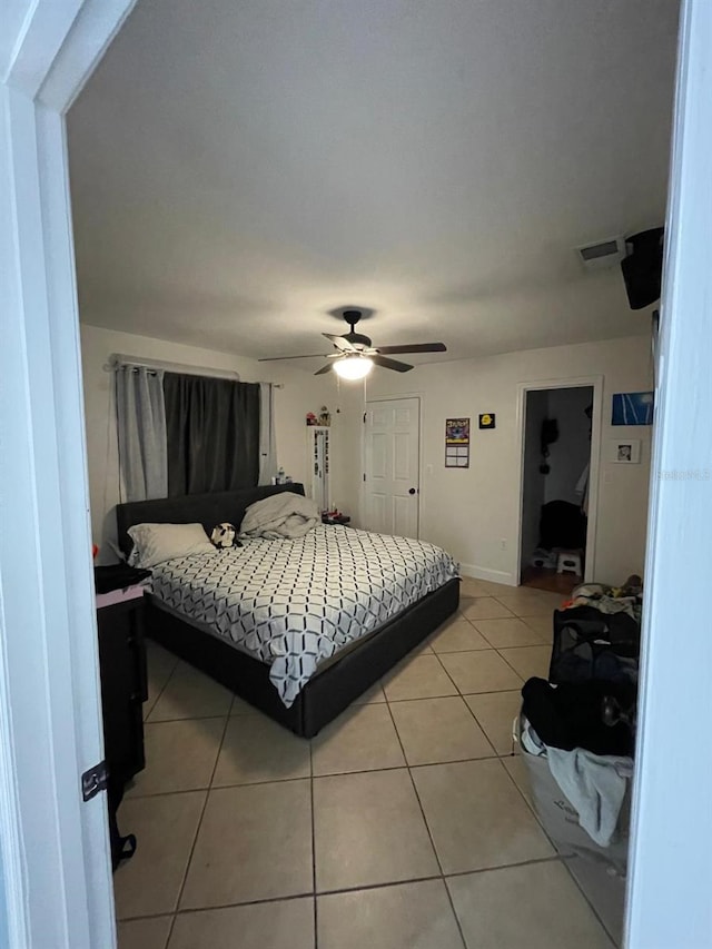 tiled bedroom featuring ceiling fan