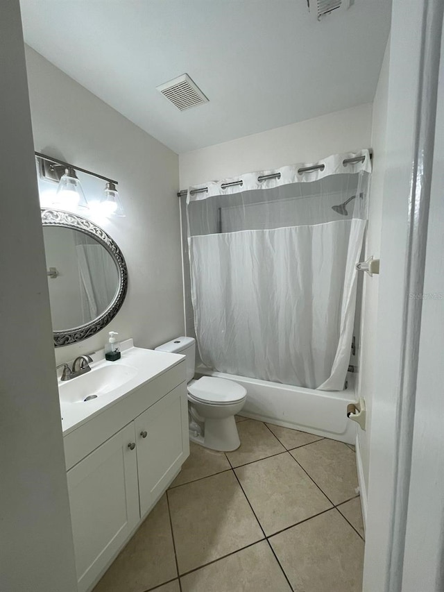 full bathroom featuring tile patterned flooring, vanity, toilet, and shower / bath combo with shower curtain