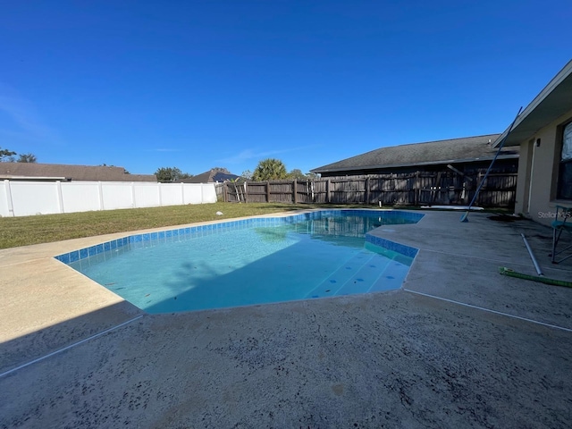 view of pool with a lawn and a patio