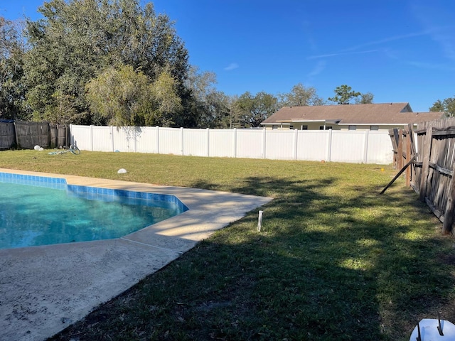 view of swimming pool with a lawn