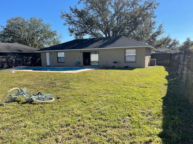 back of property featuring a yard, a fenced in pool, a patio, and cooling unit