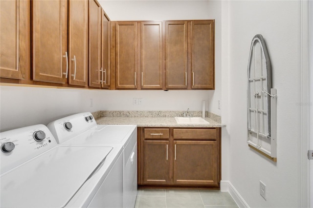 clothes washing area featuring cabinets, independent washer and dryer, sink, and light tile patterned floors