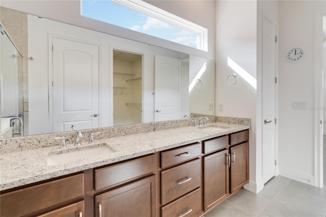 bathroom with tile patterned floors, a shower with door, and vanity