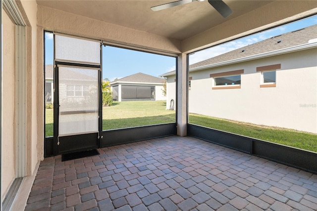 unfurnished sunroom with ceiling fan