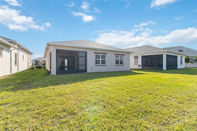 back of house featuring a lawn and a sunroom