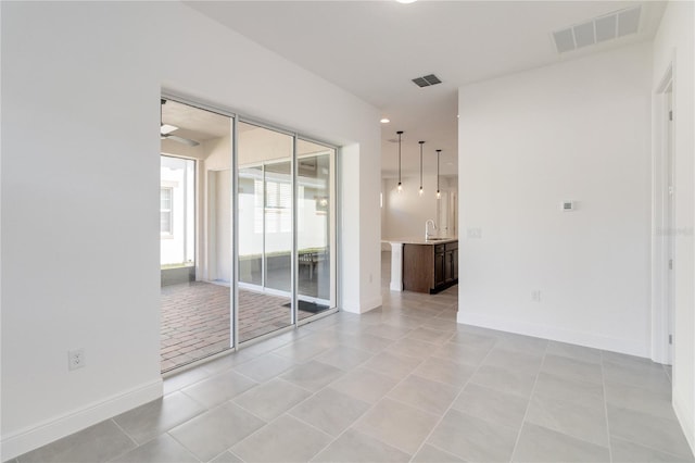 spare room with sink and light tile patterned floors