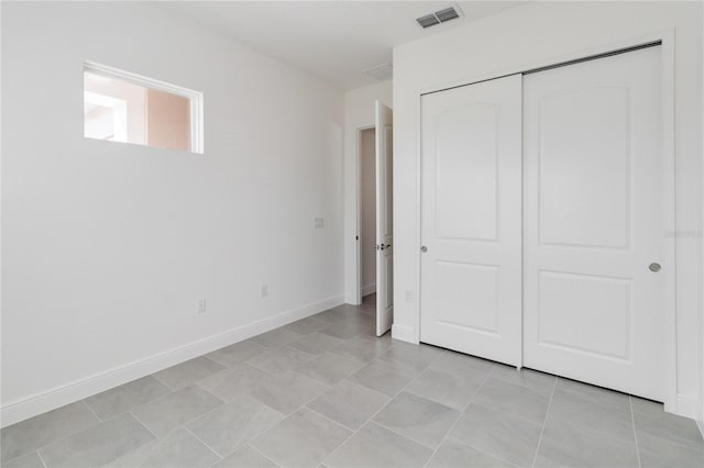 unfurnished bedroom featuring a closet and light tile patterned flooring