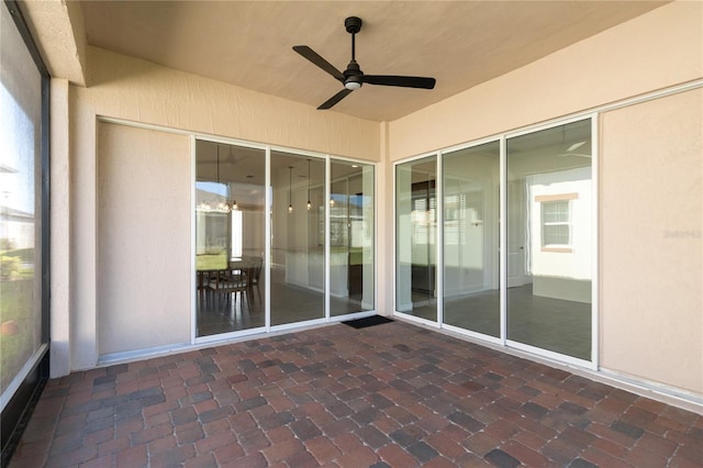 unfurnished sunroom featuring ceiling fan