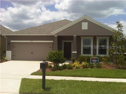 view of front of home with a garage and a front lawn