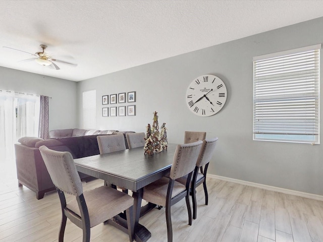 dining area with ceiling fan, light hardwood / wood-style floors, and a textured ceiling