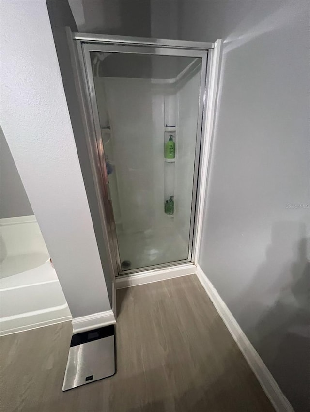 bathroom with wood-type flooring and walk in shower