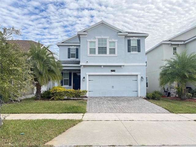 view of property featuring a front yard and a garage