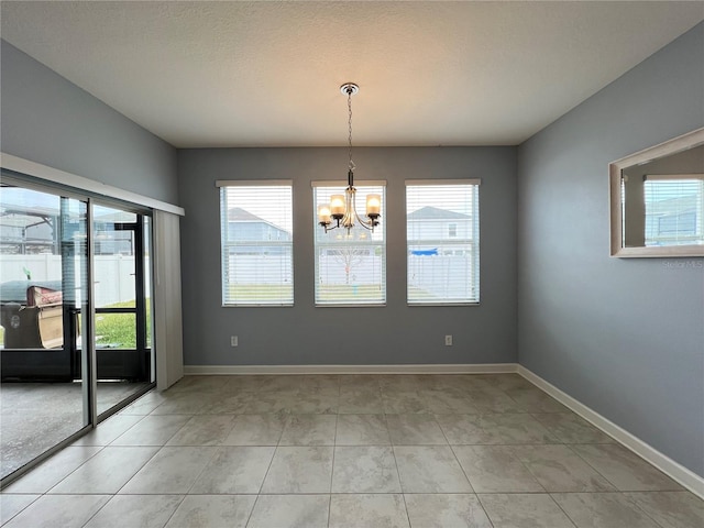 unfurnished room featuring a notable chandelier and light tile patterned floors