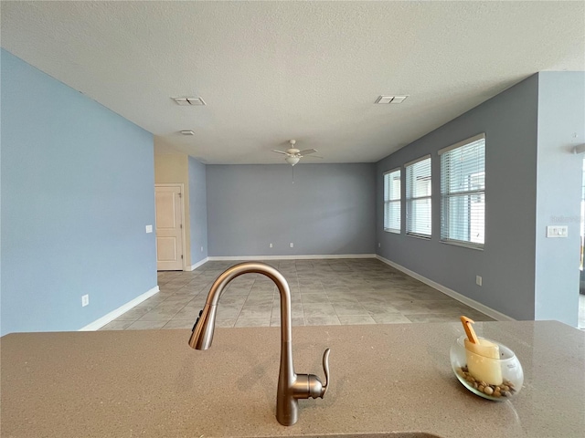 interior space featuring a textured ceiling, ceiling fan, and light tile patterned flooring