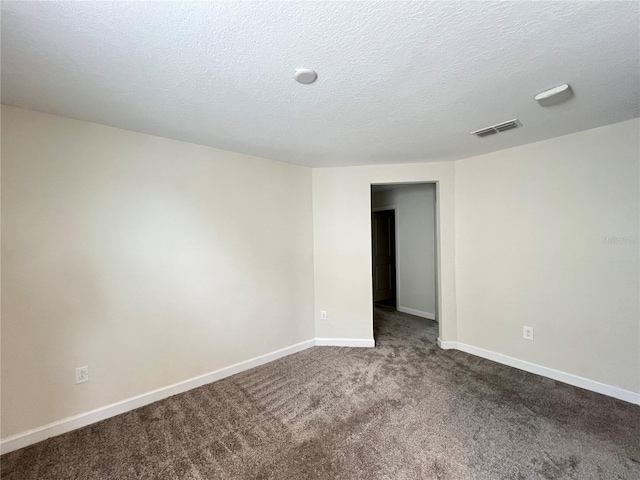 empty room with carpet flooring and a textured ceiling