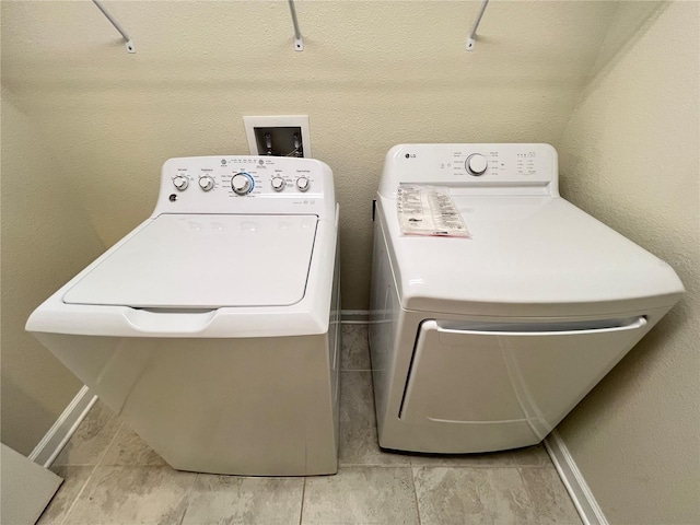 laundry area featuring separate washer and dryer and light tile patterned flooring