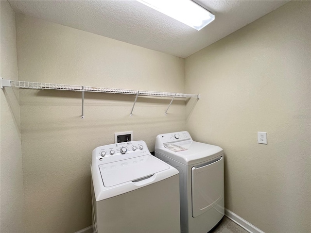 laundry room featuring washing machine and dryer and a textured ceiling