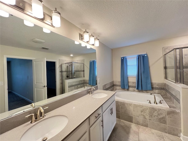 bathroom with tile patterned floors, vanity, a textured ceiling, and shower with separate bathtub