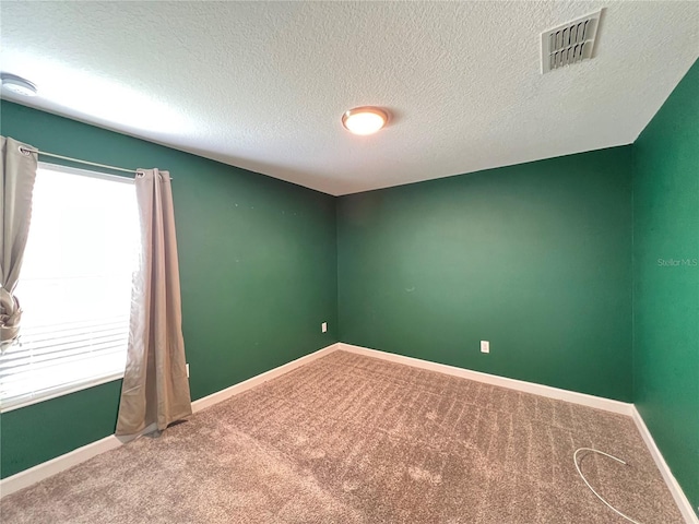 carpeted spare room with a textured ceiling