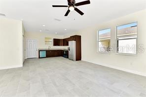 unfurnished living room featuring ceiling fan