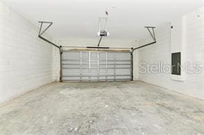 garage with electric panel and a garage door opener