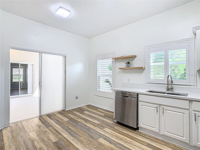 kitchen with sink, white cabinets, stainless steel dishwasher, and light wood-type flooring