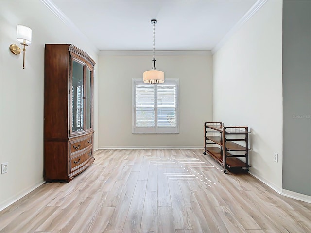 spare room with light hardwood / wood-style floors and crown molding